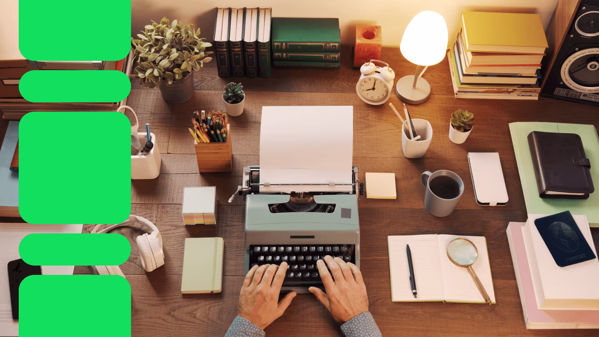 Hands typing on vintage typewriter at wooden desk with books, lamp, plants, coffee cup, and writing supplies in warm lighting.