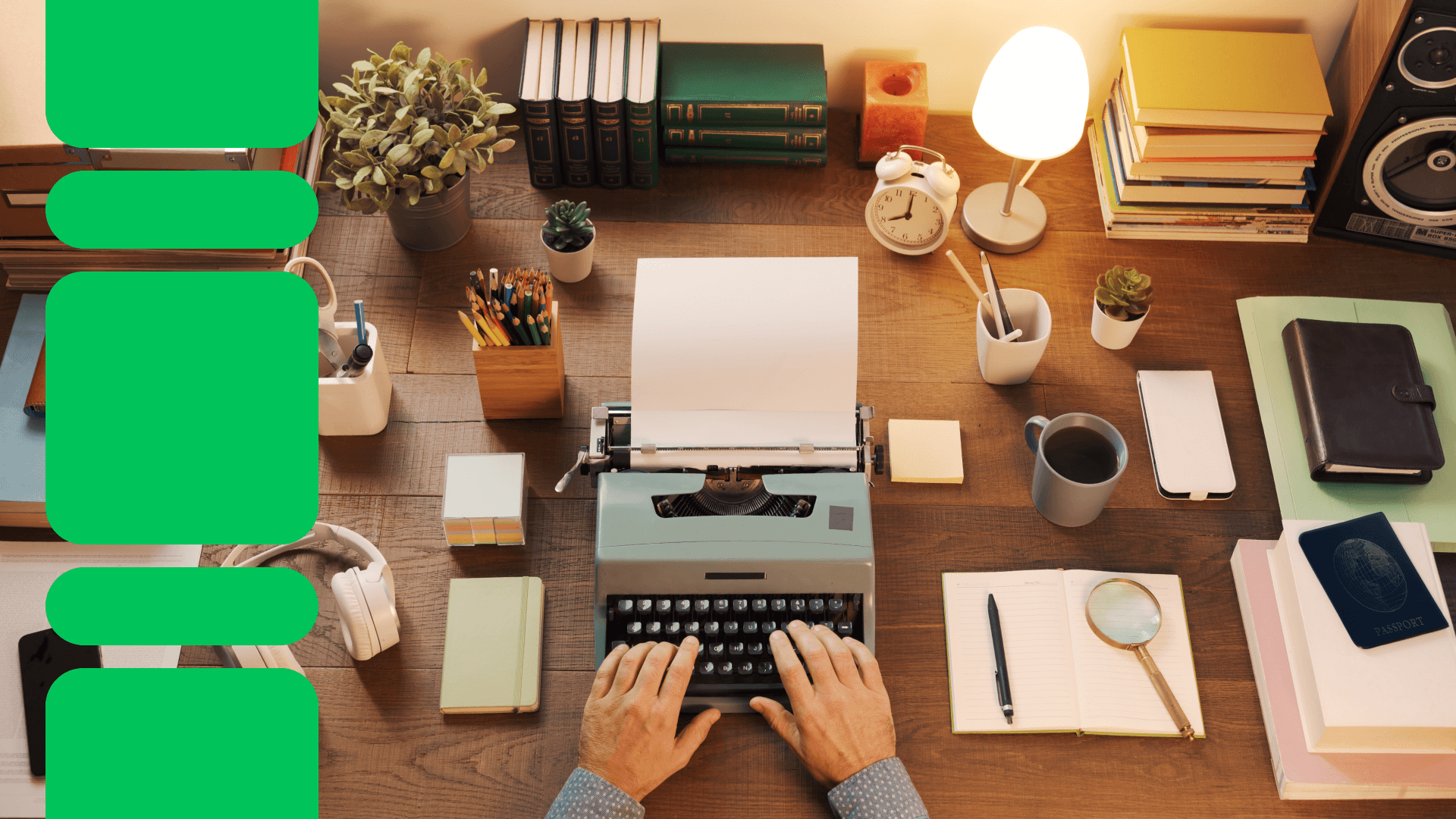 Hands typing on vintage typewriter at wooden desk with books, lamp, plants, coffee cup, and writing supplies in warm lighting.