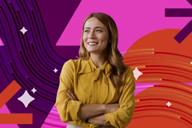 A smiling woman in a yellow blouse stands with arms crossed against a vibrant pink, purple, and orange graphic background.