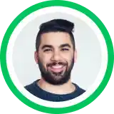 Headshot portrait of a smiling person with dark beard against gray background in circular green frame