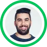 Headshot portrait of a smiling person with dark beard against gray background in circular green frame