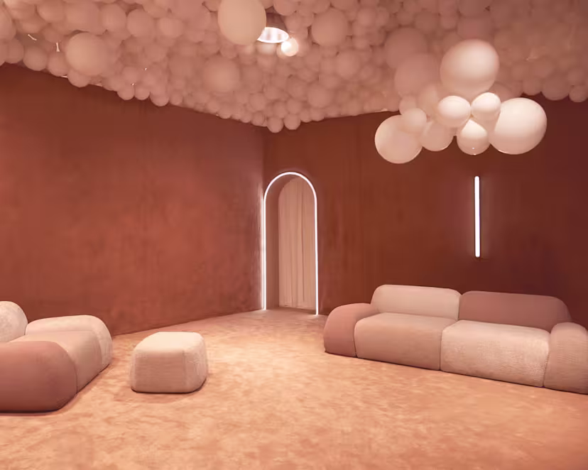 A terracotta room with cream balloon ceiling installation, modular sofas, a glowing arched doorway, and soft ambient lighting.