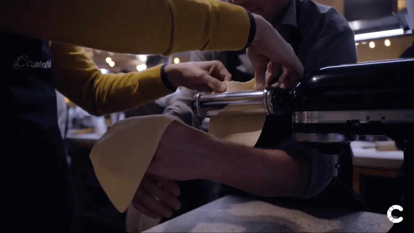 Hands working at a dimly lit bar or restaurant counter, with soft overhead lighting creating an atmospheric ambiance
