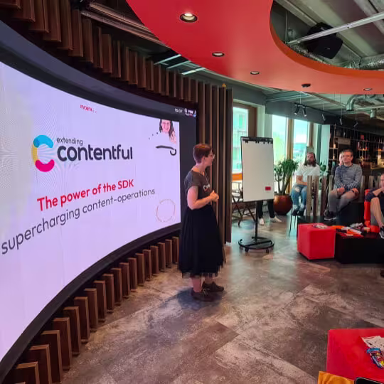 Presenter speaking before curved screen showing extending Contentful SDK slide