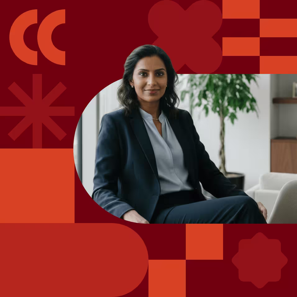 A professional woman in a dark blazer sits confidently in an office, framed by a bold red graphic background with decorative shapes.