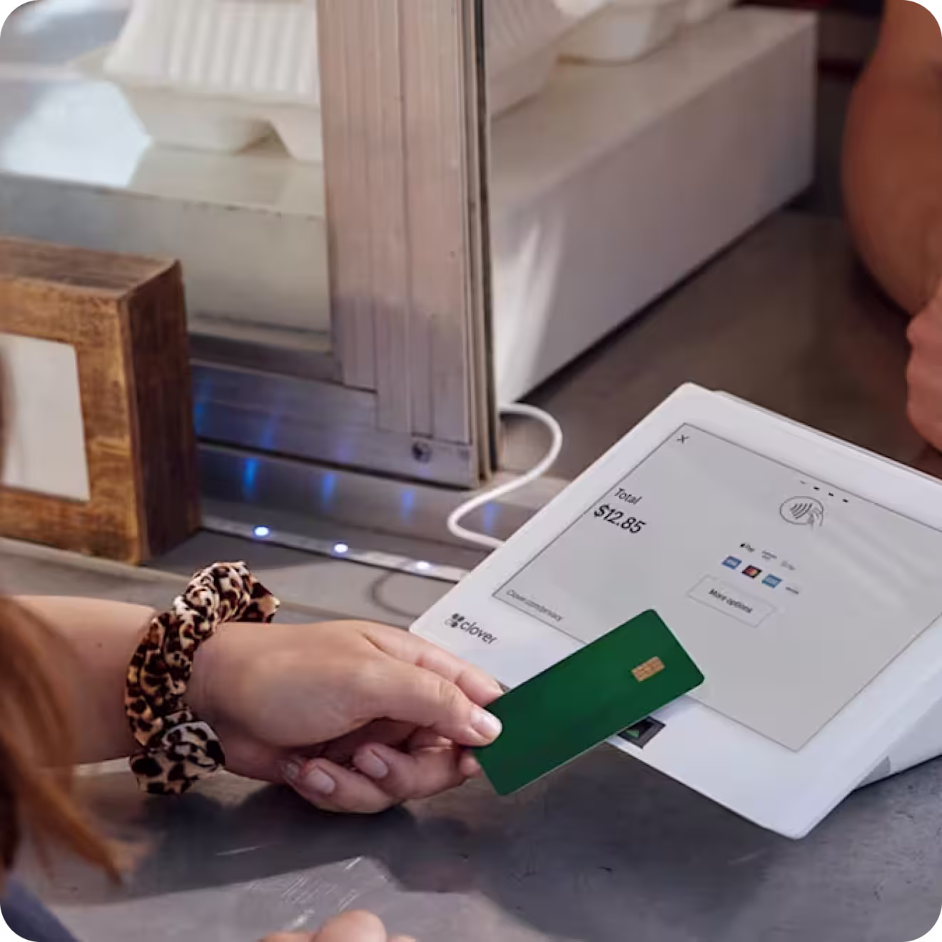 Female making a touchless payment using her bank card on a Clover payment terminal