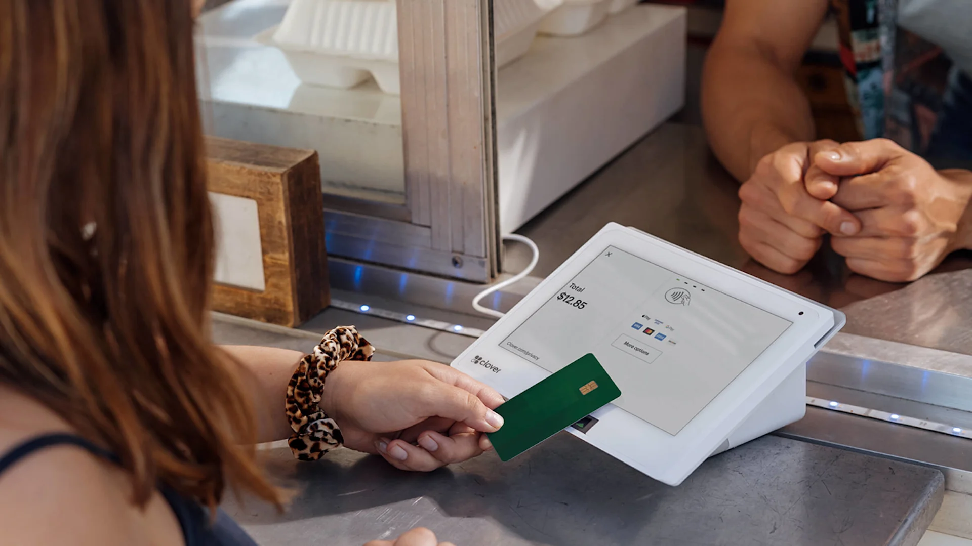 Female making a touchless payment using her bank card on a Clover payment terminal