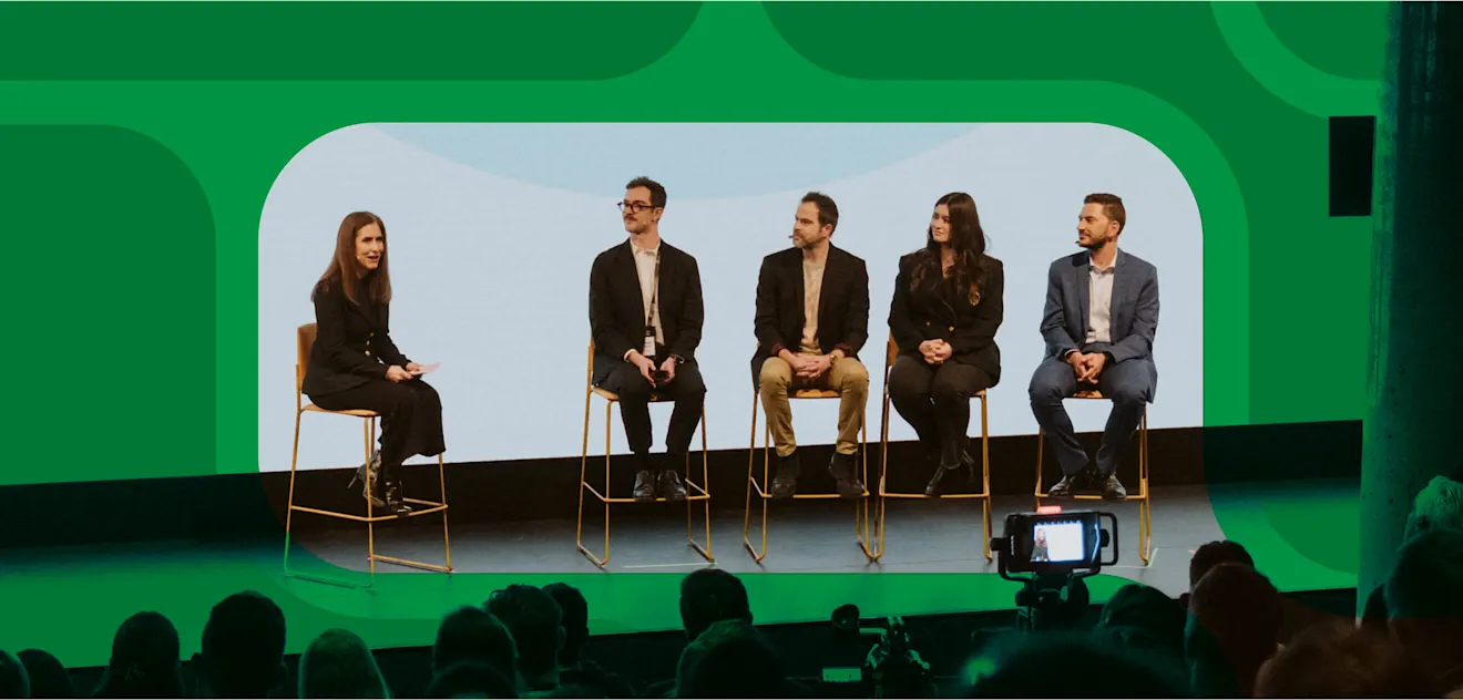 Four panelists on Contentful's stage with a host in front of green contentful iconography